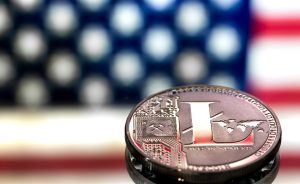 A close-up image of a Litecoin coin with a digital design, set against a blurred American flag background, symbolizing the concept of virtual money and cryptocurrency.