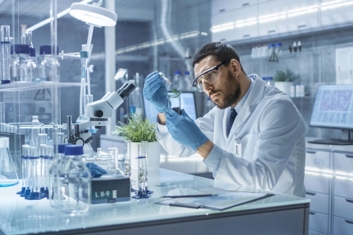 Scientist working in a modern laboratory with advanced equipment and plants under analysis, representing research, innovation, and the growth potential of biotechnology startups.